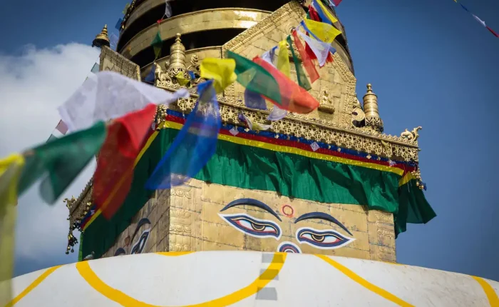 A close-up shot of the iconic wisdom eyes of Buddha painted on the golden spire of Swayambhunath Stupa