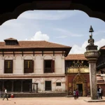Tourists exploring the courtyard of the 55 Window Palace with a view of the famous Golden Gate and King Bhupatindra Malla monument.