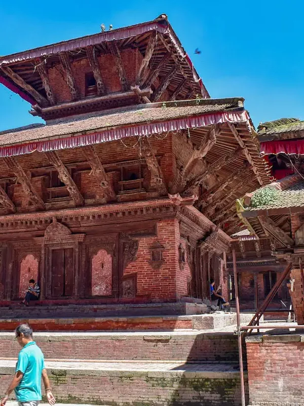 The multi-tiered wooden and brick structure of the Jagannath Temple against a bright blue sky at Kathmandu Durbar Square.