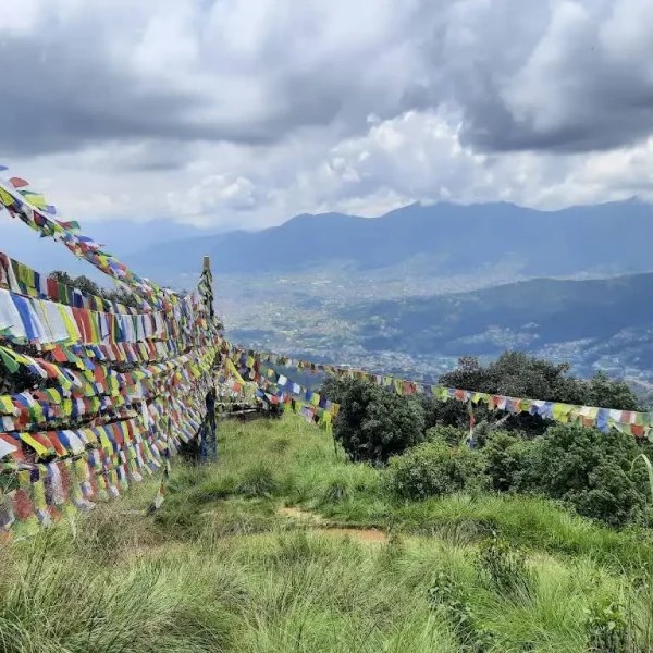 Thousands of colorful Buddhist prayer flags stretched across a grassy hilltop ridge on the Nagarjun Jamacho day hike route.