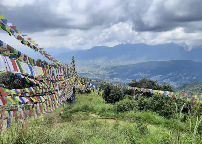 Thousands of colorful Buddhist prayer flags stretched across a grassy hilltop ridge on the Nagarjun Jamacho day hike route.