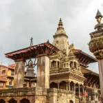 The stone-built Vatsala Durga Temple next to the famous bronze statue column of King Bhupatindra Malla in Bhaktapur Durbar Square.